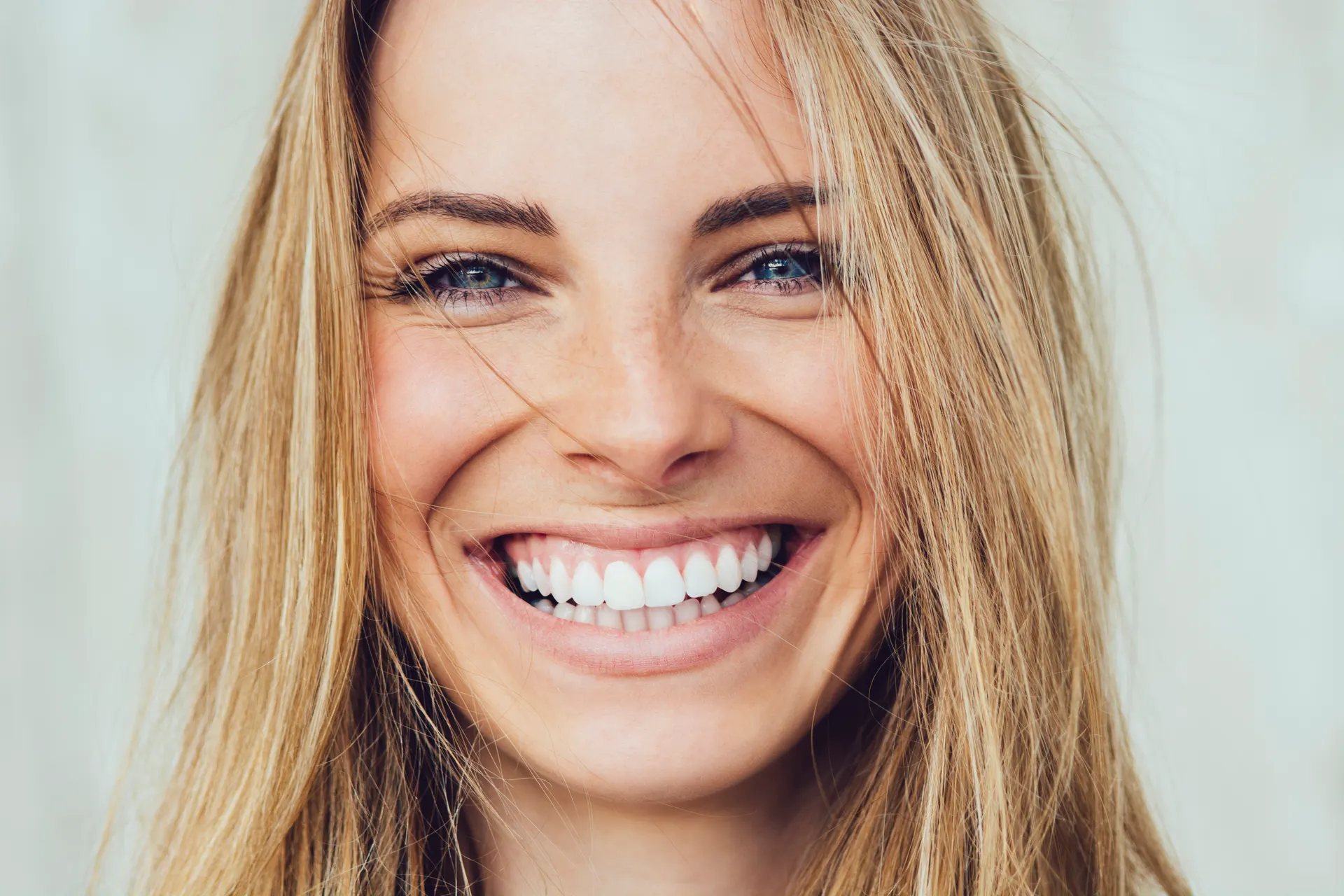 Junge Frau mit strahlendem Lächeln – Ergebnis sanfter, ästhetischer Zahnmedizin bei DentsPro